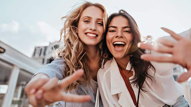 Due giovani donne che sorridono all'aperto